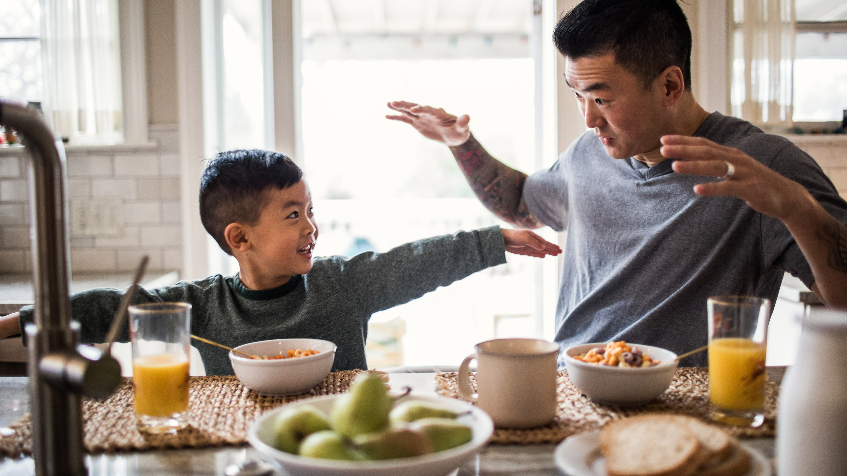 Father and son having breakfast in kitchen