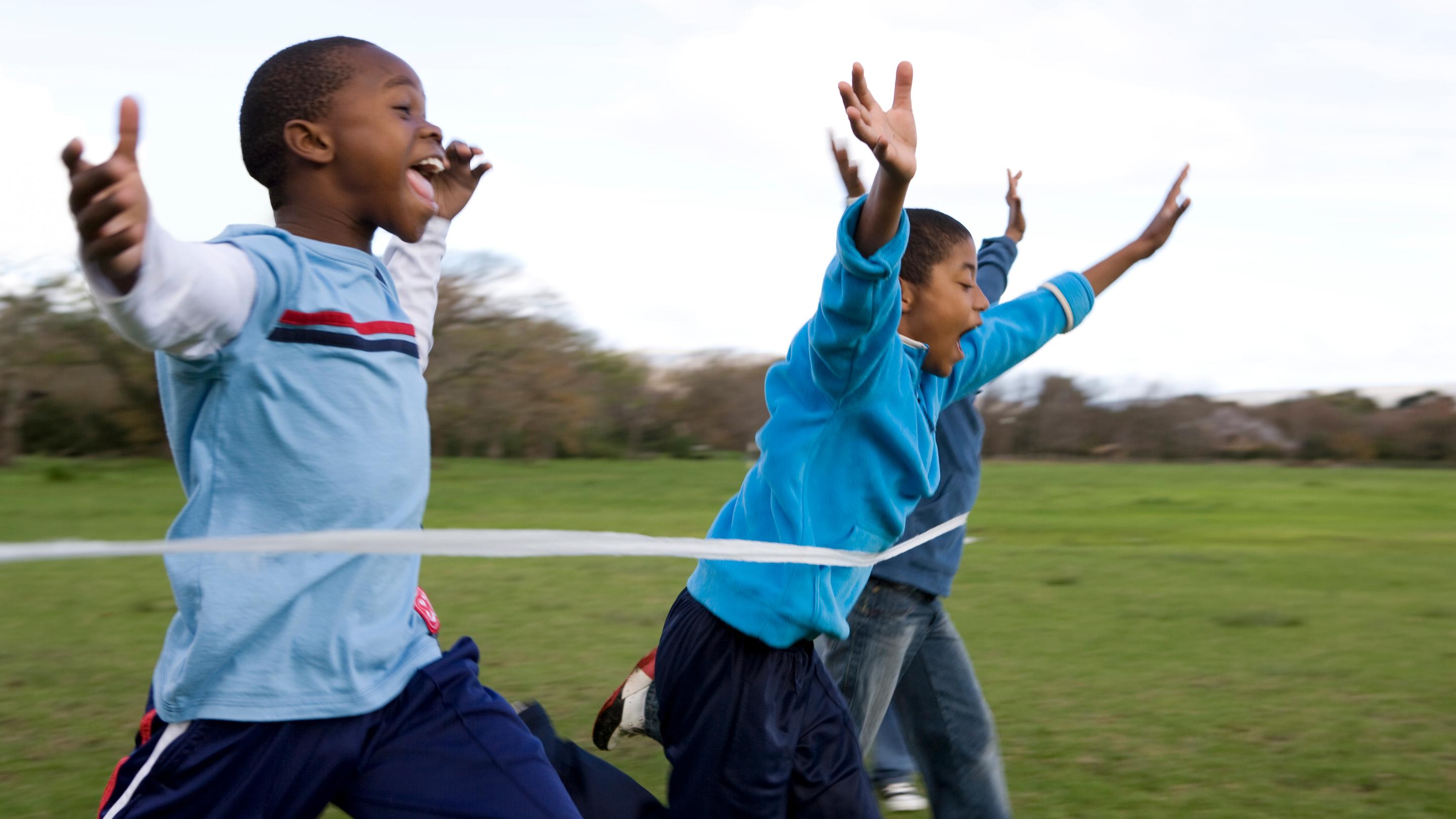 Group of boys running through finishing line