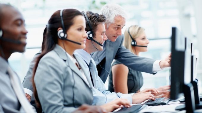 Portrait of a senior business manager with representatives in a call center