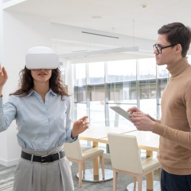 Young female developer making a presentation to colleague with tablet