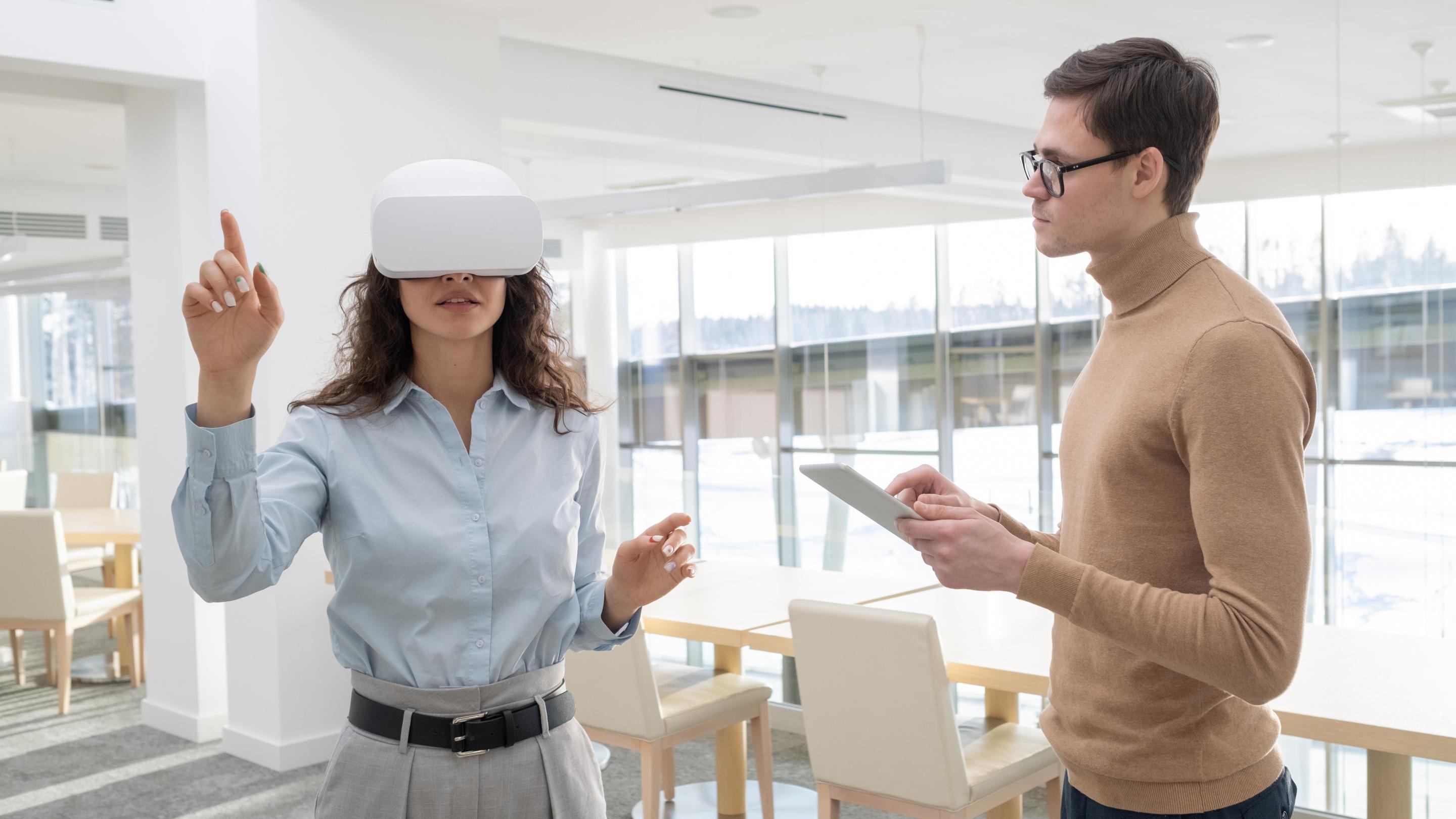 Young female developer making a presentation to colleague with tablet