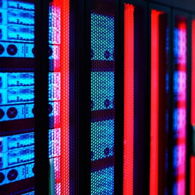 Servers and technology in a data center lit with colored lights