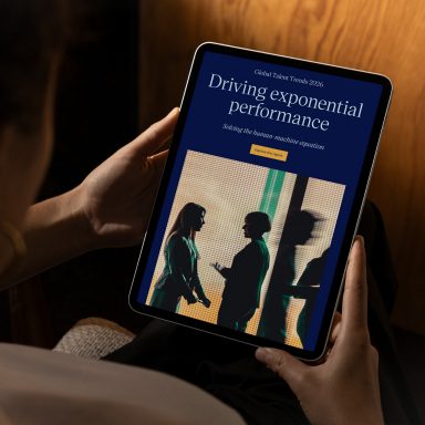 Over the shoulder view of a woman using a digital tablet with the Global Talent Trends report on screen