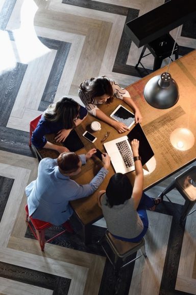 Young Chinese colleagues working together in a busy co-working space from above