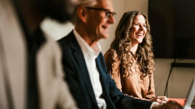 Meeting takes place with smiling people in office setting