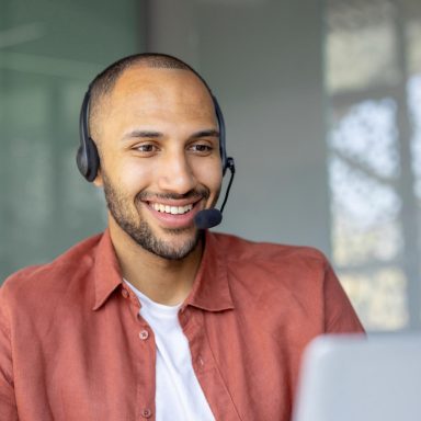 Man works on computer with headset