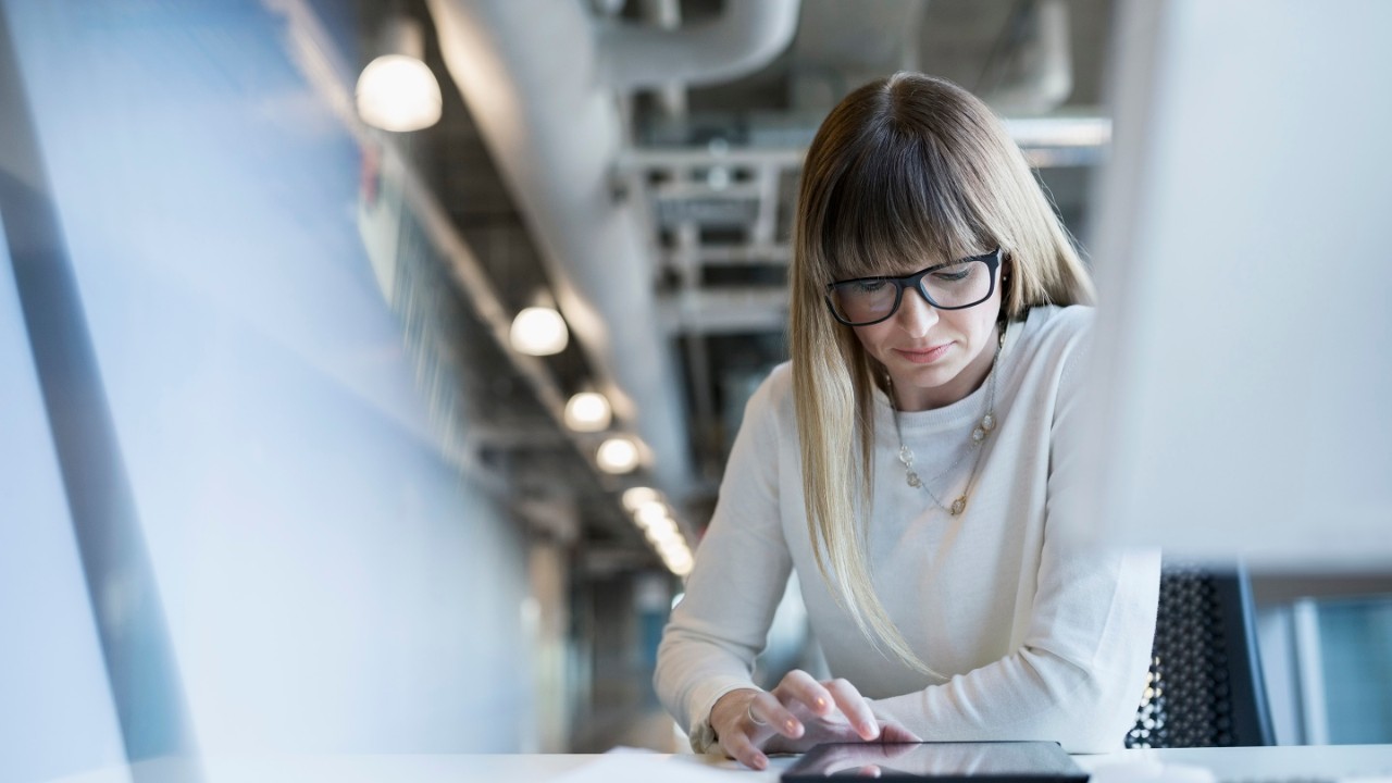 Businesswoman using digital tablet at office desk