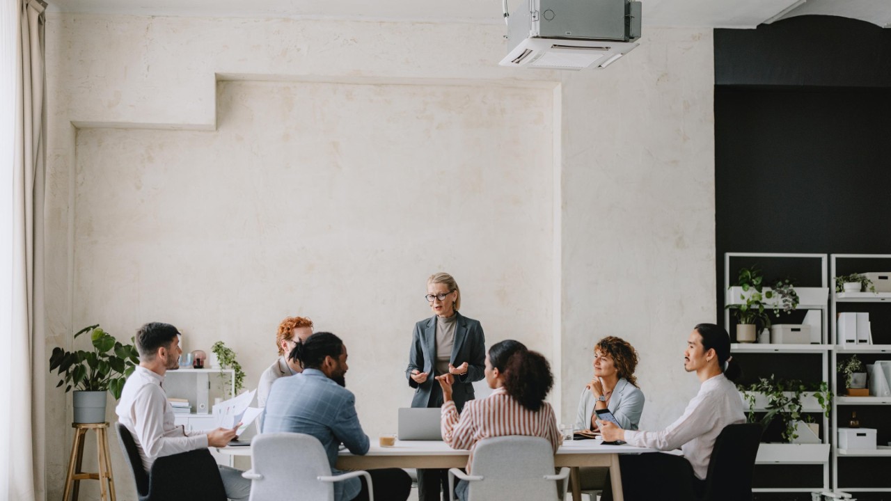 Bild eines Business Meetings in einer hellen beigen Office-Umgebung.