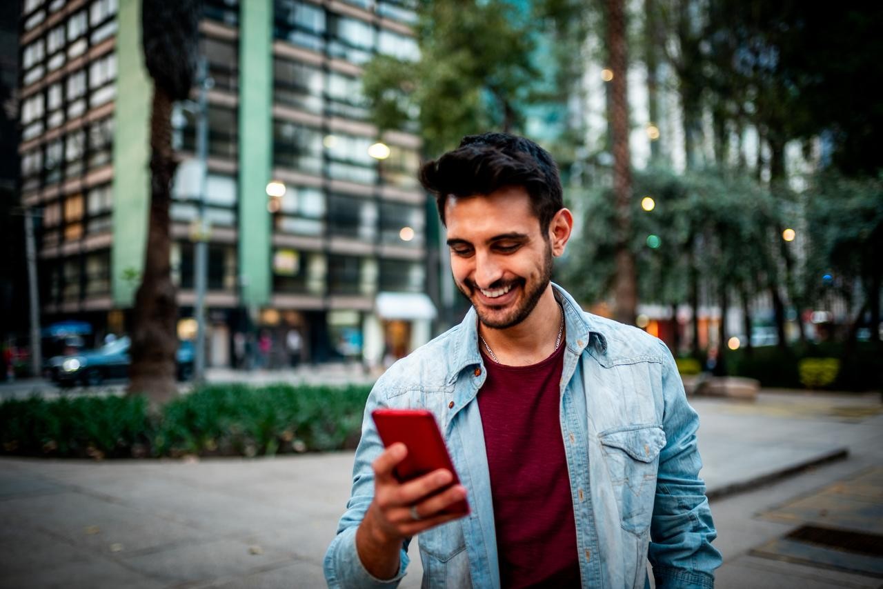 man smiling looking at phone