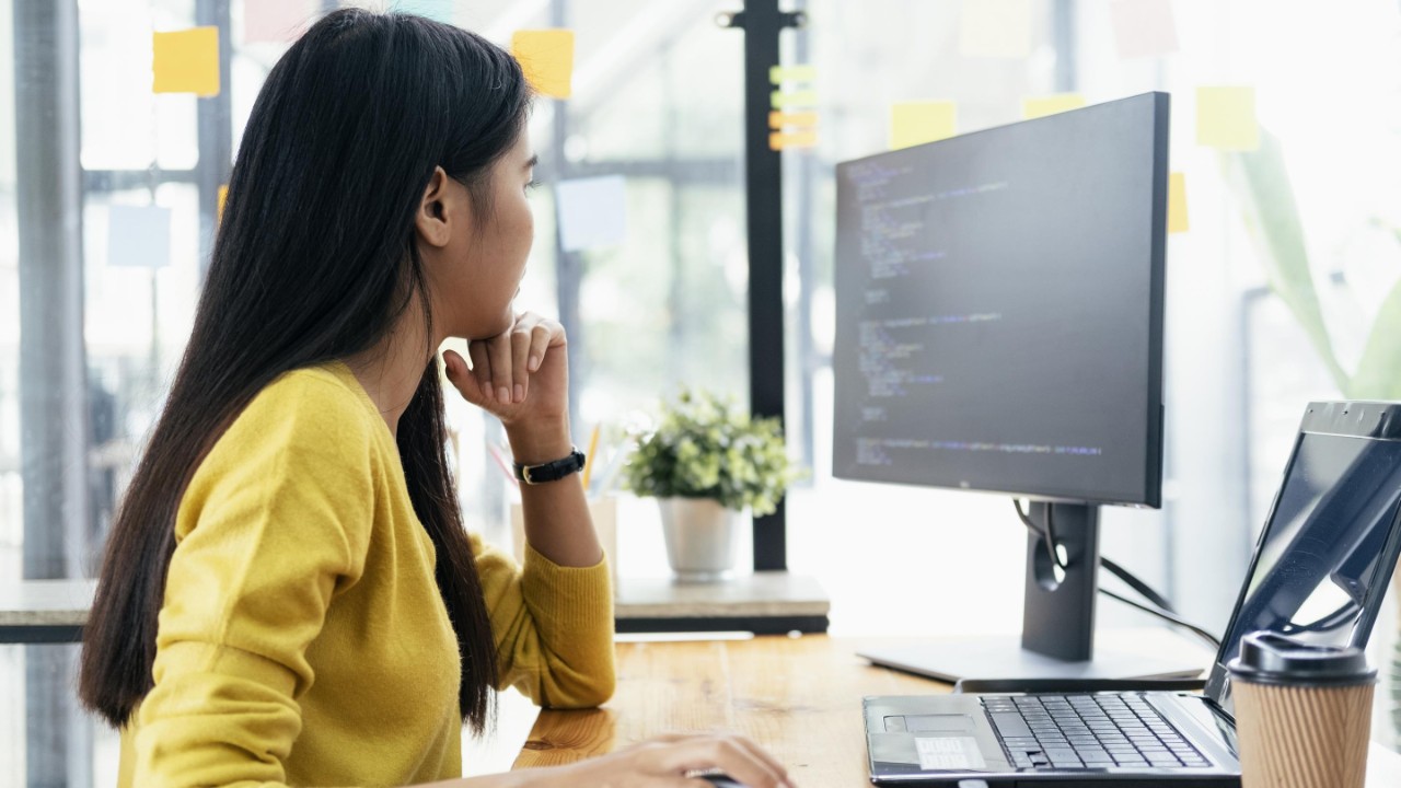 Women with yellow shirt is coding and developing software.
