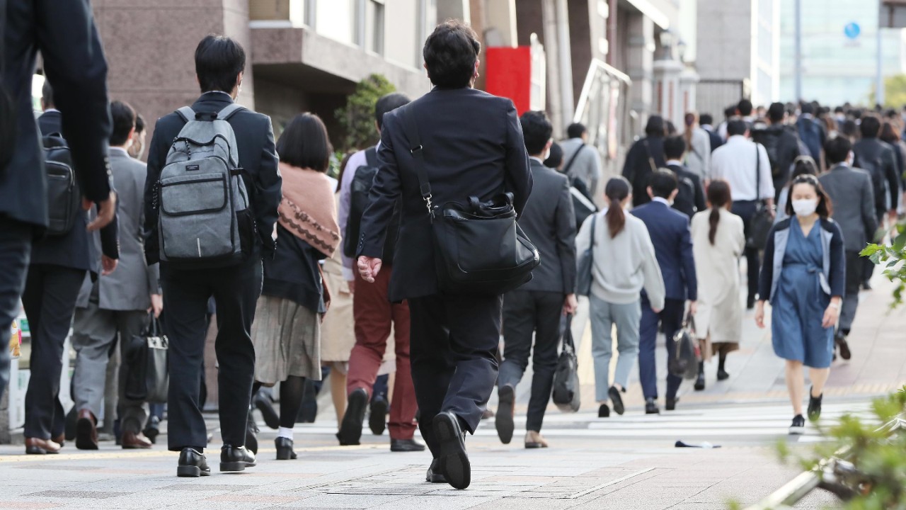 Crowd of people walking past office building