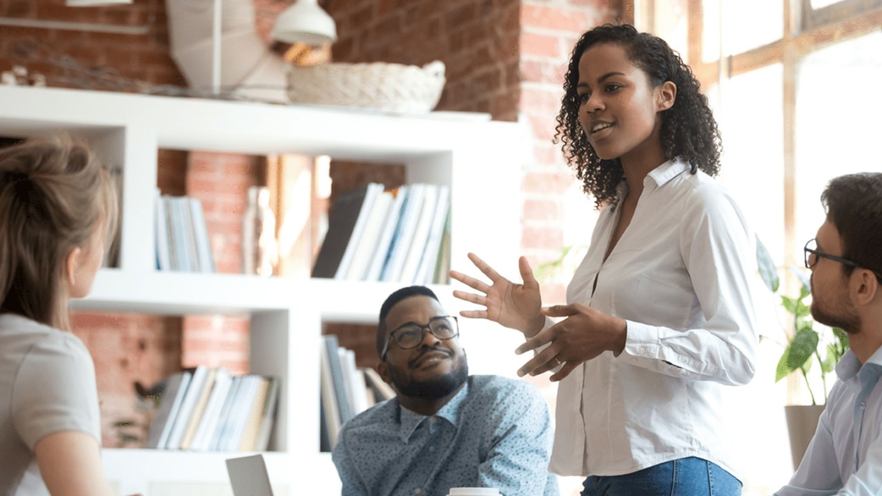 Person standing and presenting in a small team meeting