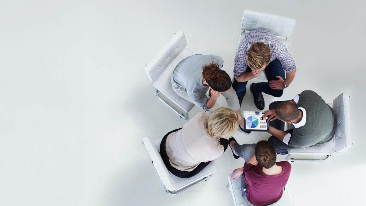 High angle view of businesspeople using digital tablet together in office