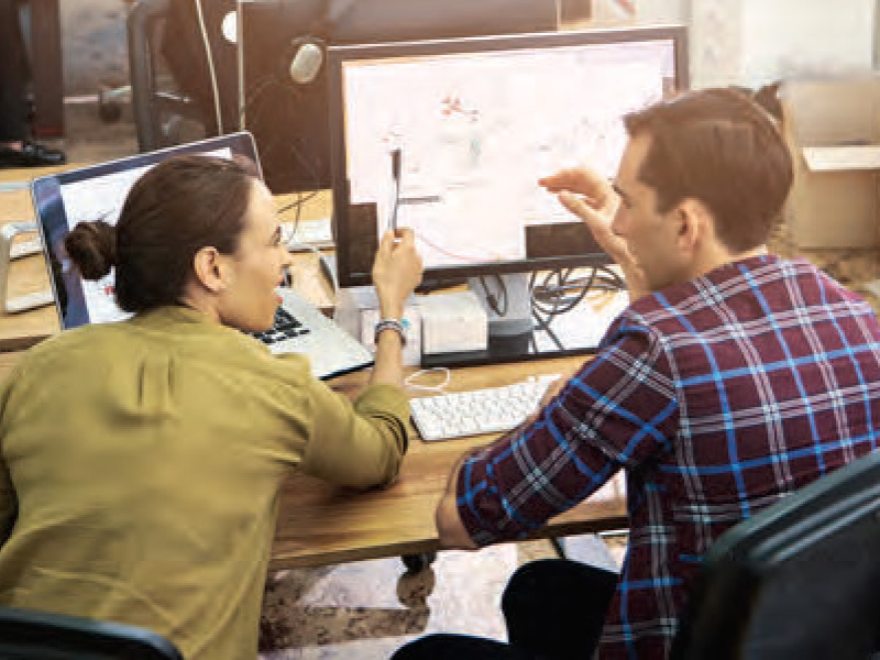 Man and woman talking in front of computers 800x600