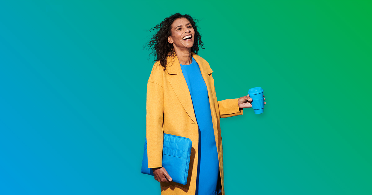 Smiling woman holds a cup in a hand