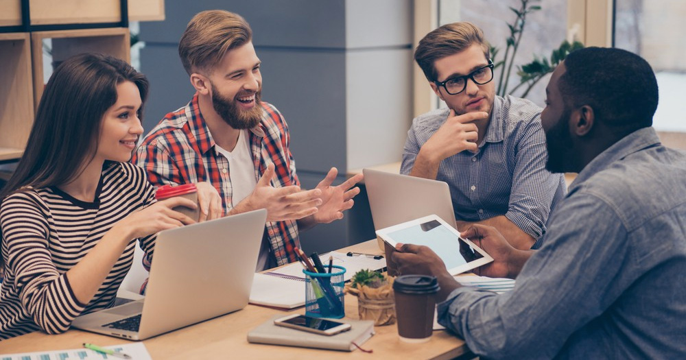 Group of young people having discussion in a meeting room 1000x525