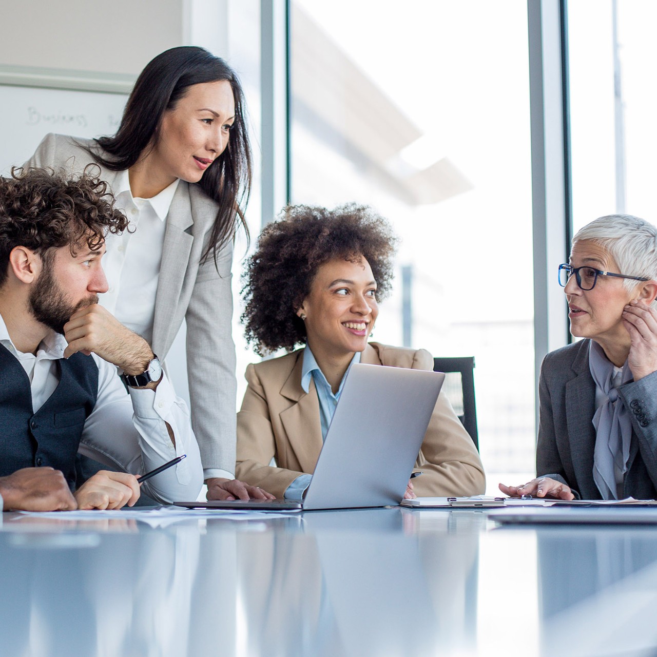 A mature CEO and her team of professionals having a briefing before the work.