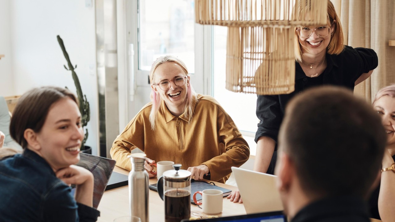 Group of people working and having coffee while laughing