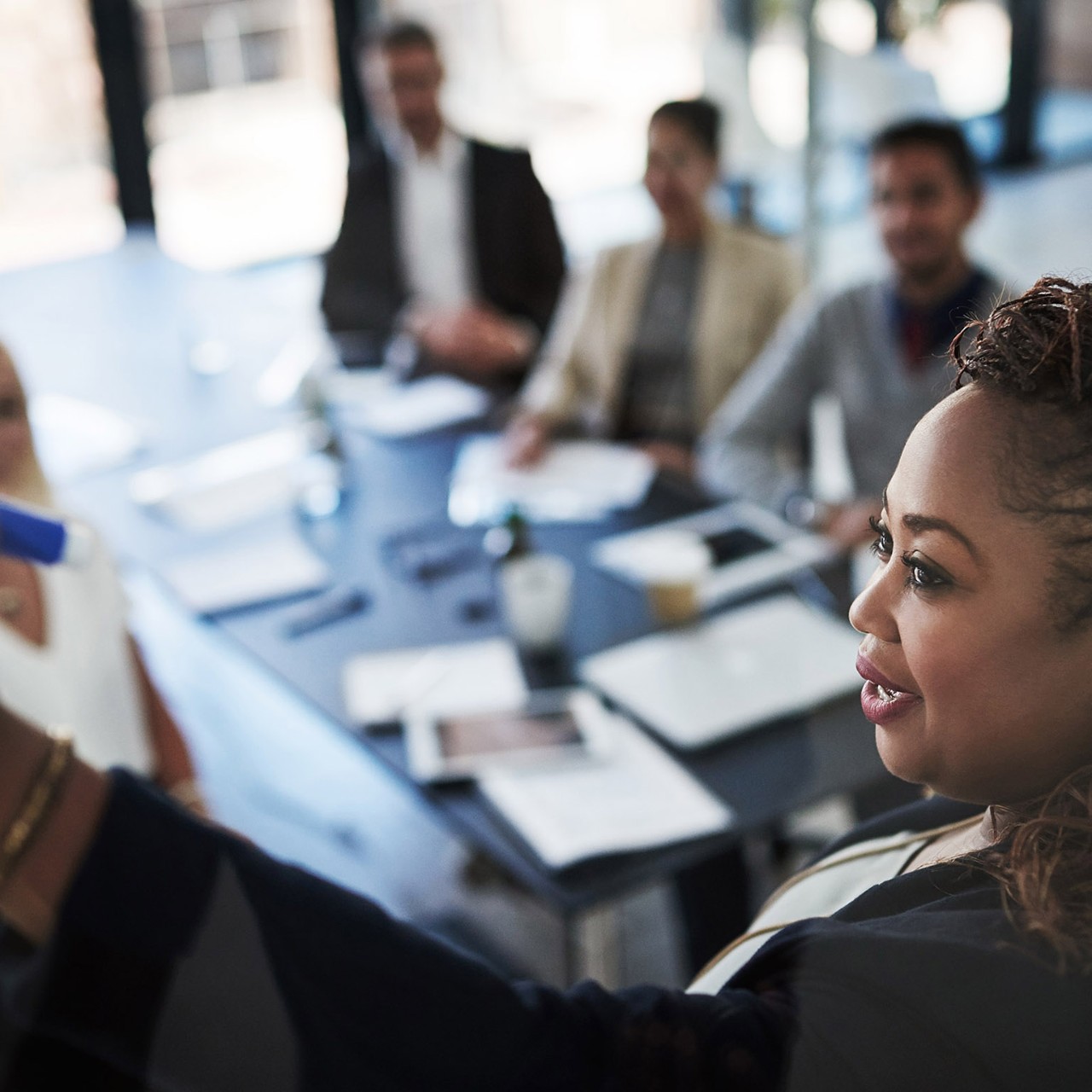 High angle shot of a young businesswoman explaining work related stuff during a presentation to work colleagues in a boardroom