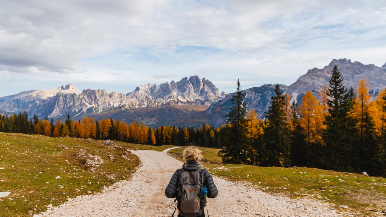 891963 Rear view of female hiker hiking at Dolomites Alps, Cortina, Italy