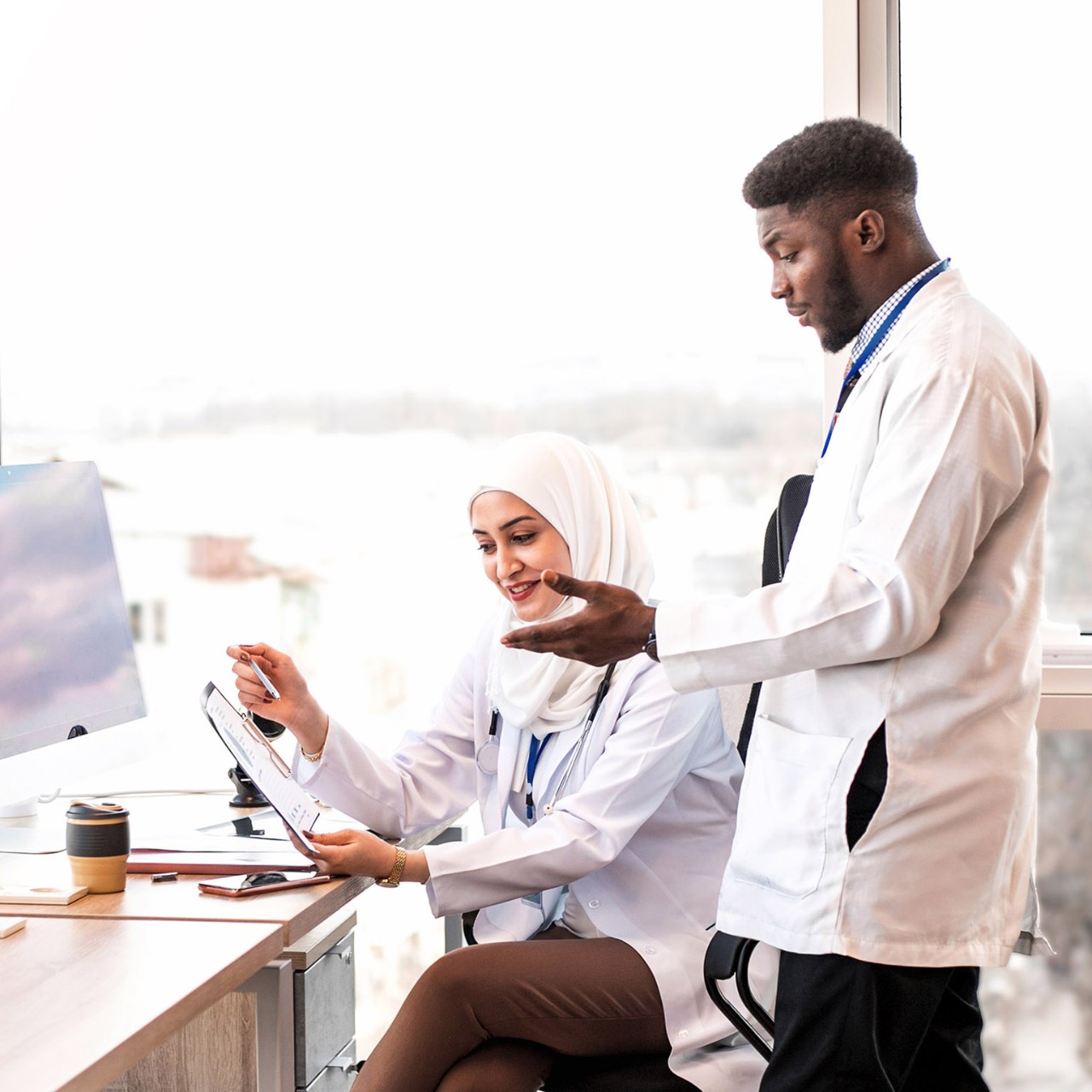 1217816117 Two medical doctors looking reports at the light medical office.
