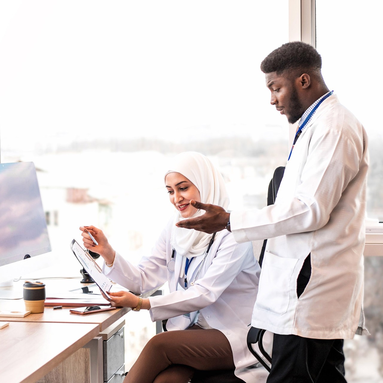 Two medical doctors looking reports at the light medical office.