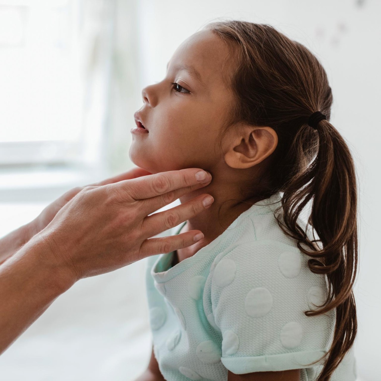 Girl has glands checked by medical professional