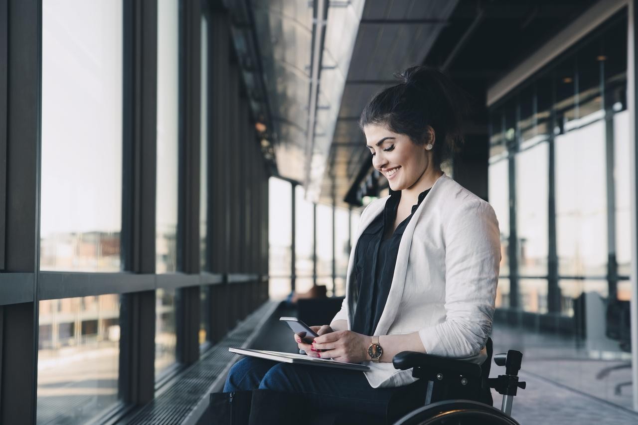 Yound lady smiling looking at iPad tablet in office