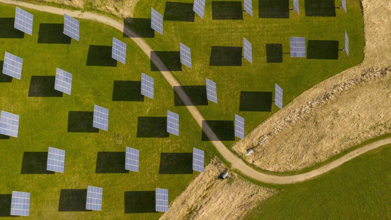 Birds eye view of green fields with solar panels