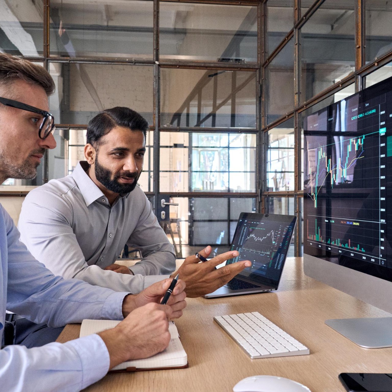 Two stock brokers study trading charts