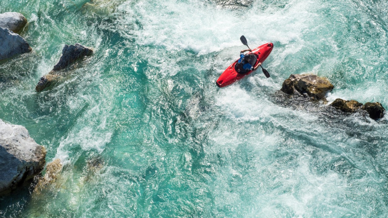 Birds eye view of person kayaking through rough water