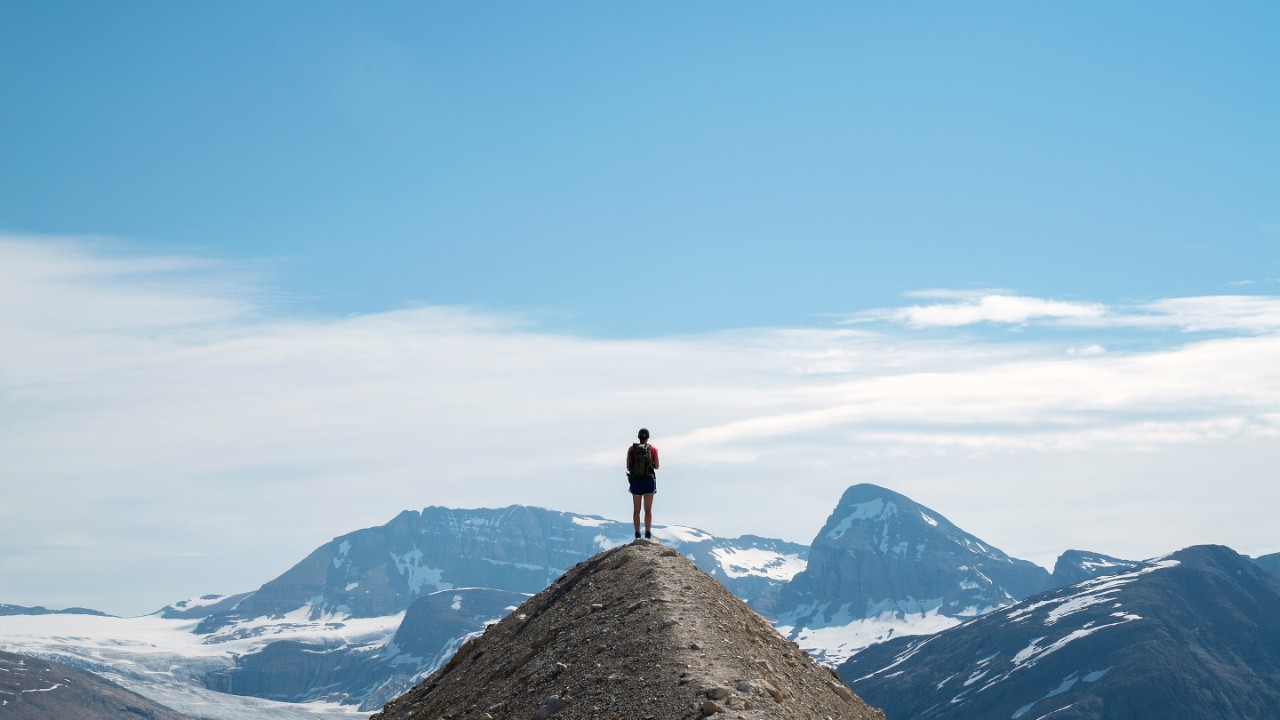 Rear View Of Man Standing On Mountain Against Sky