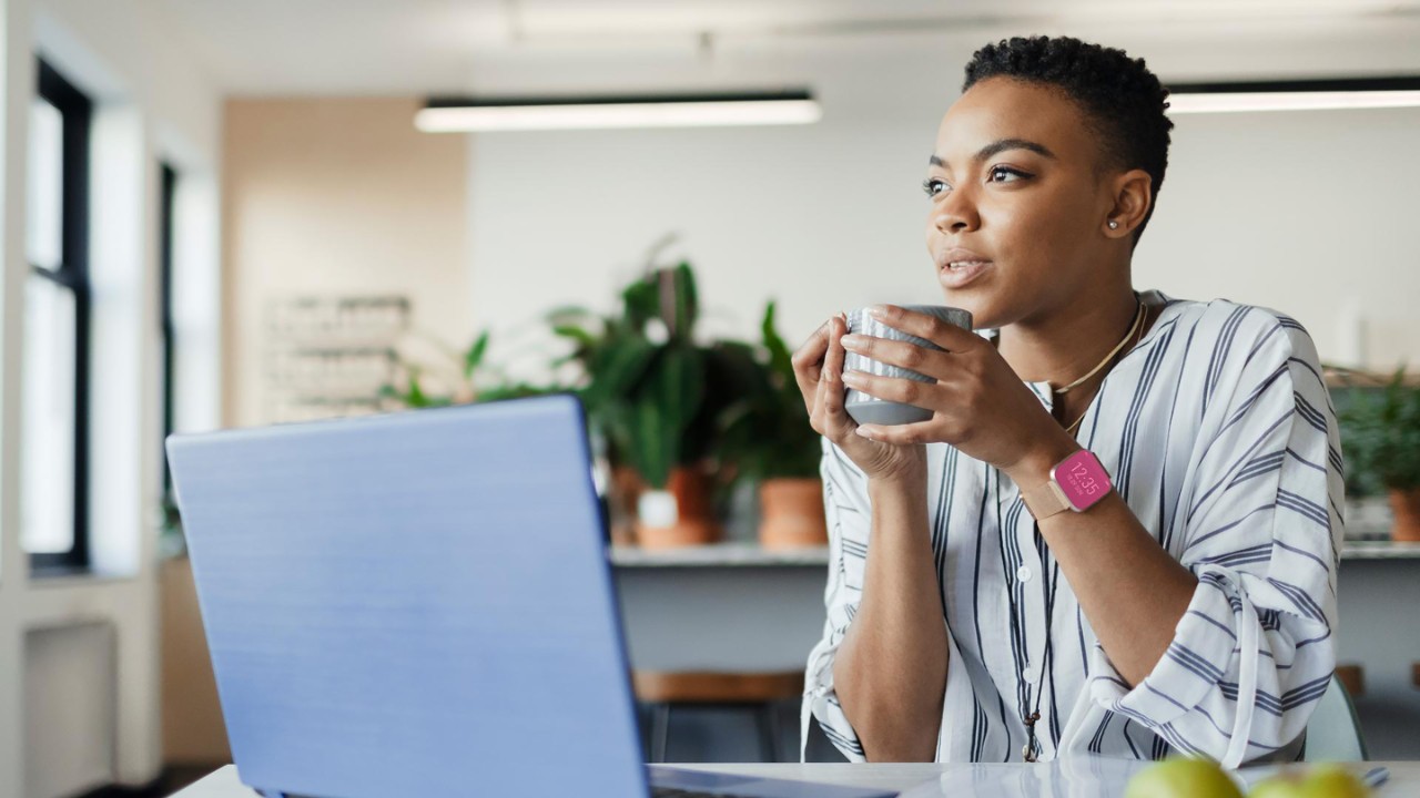 Woman drinking cofee while at the laptop