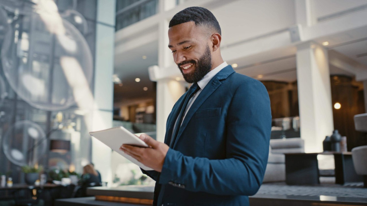 Businessman, holding digital tablet at hotel conference lobby