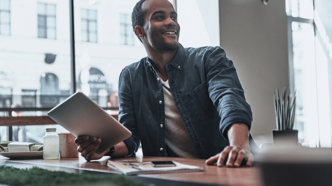 man sitting at desk with tablet