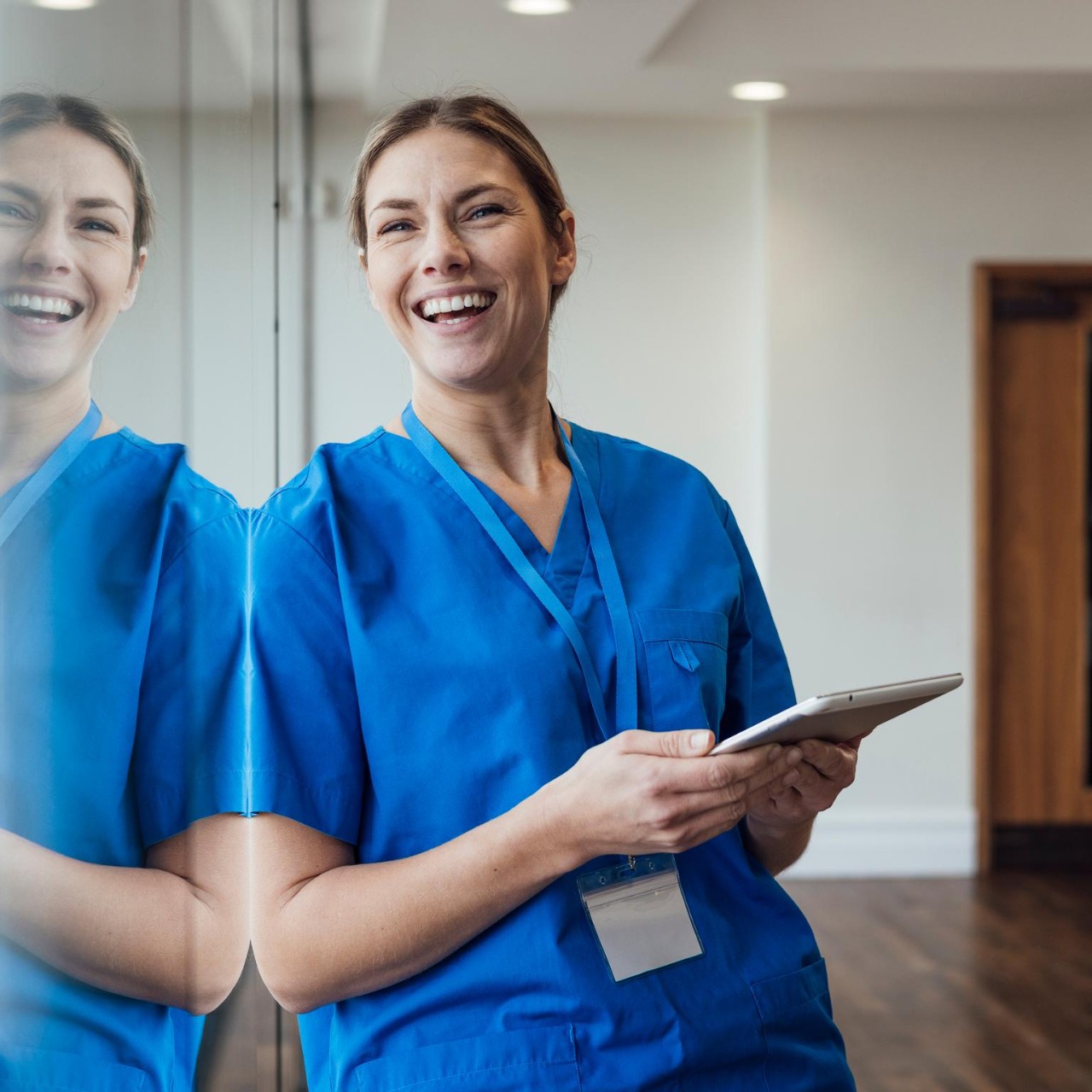 healthcare professional leaning against a window
