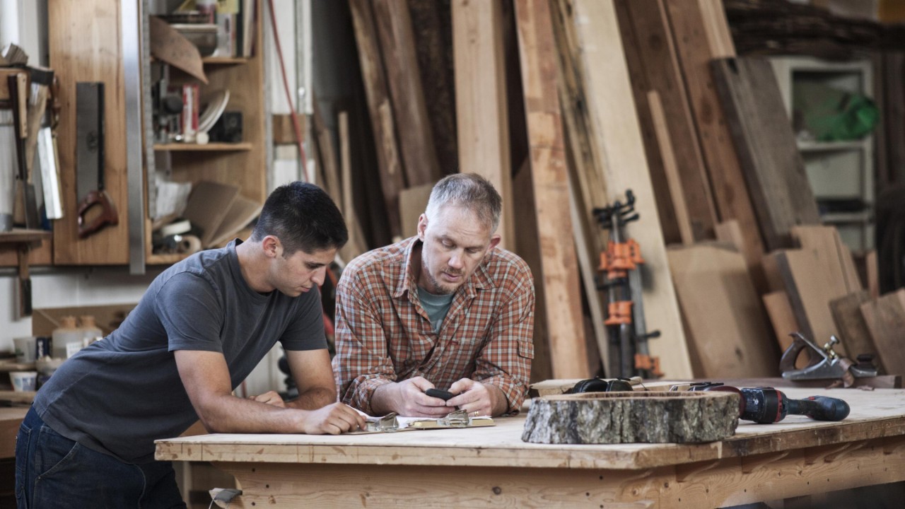 two people at a woodworking bench solving a challenge
