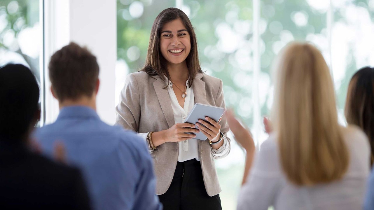 Multi-ethnic group clapping after a presentation.