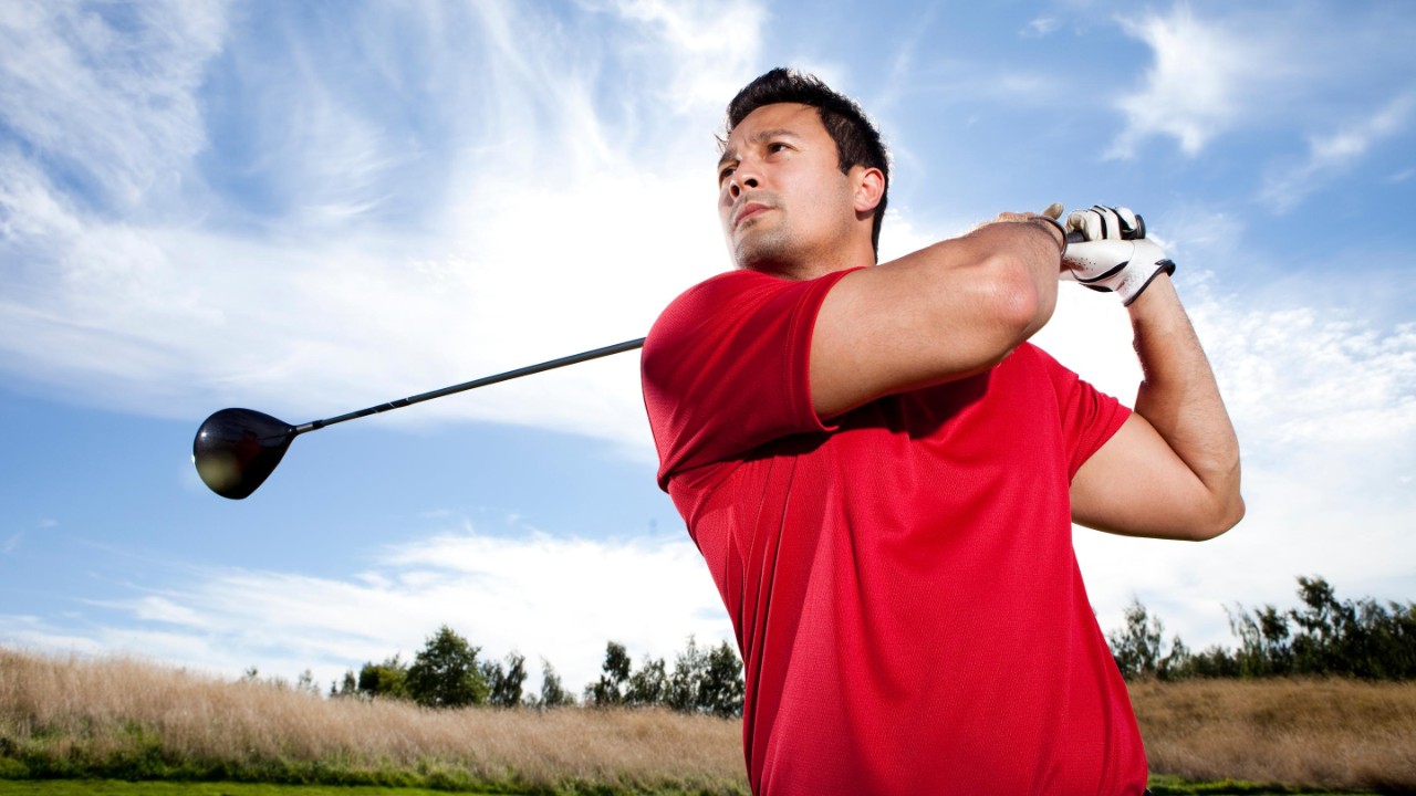 Man hitting ball golf course