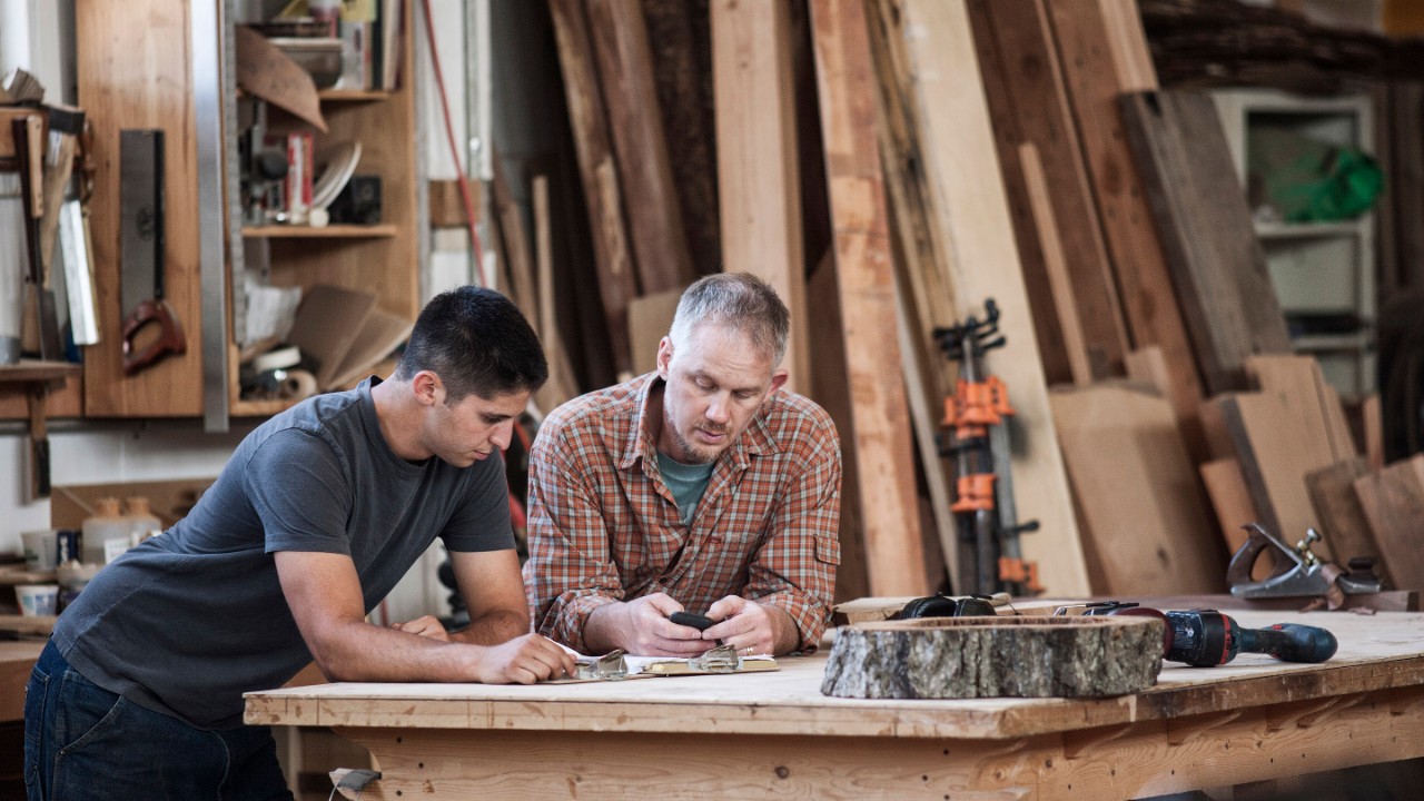 two people at a woodworking bench solving a challenge
