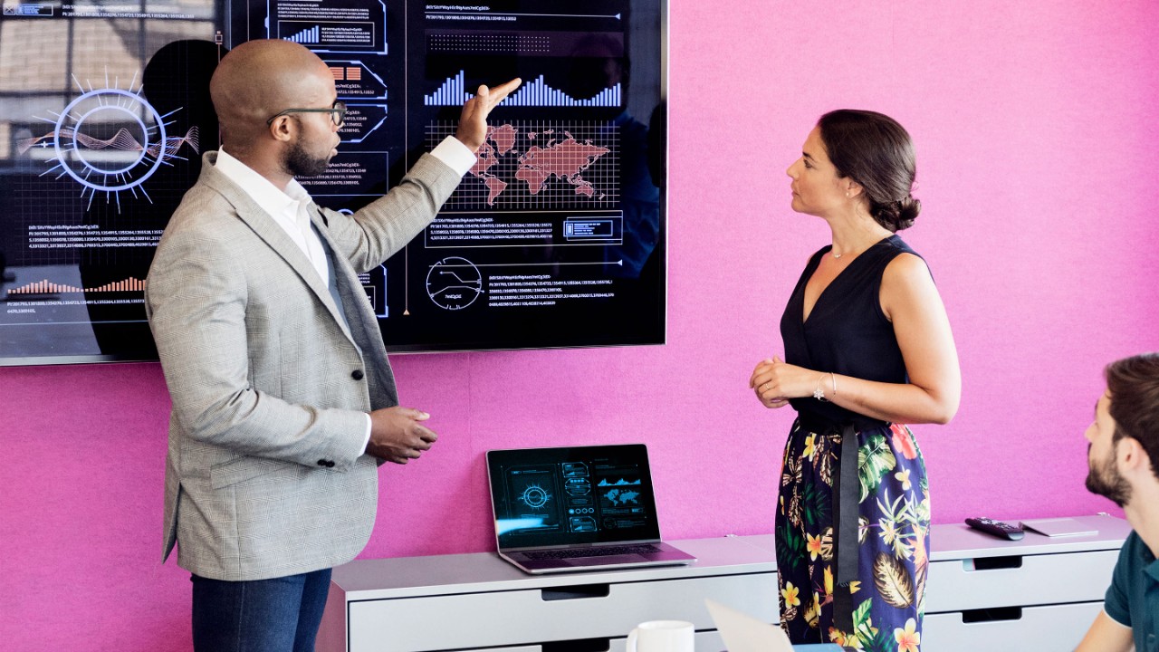 Businessman using graphs on screen in business meeting