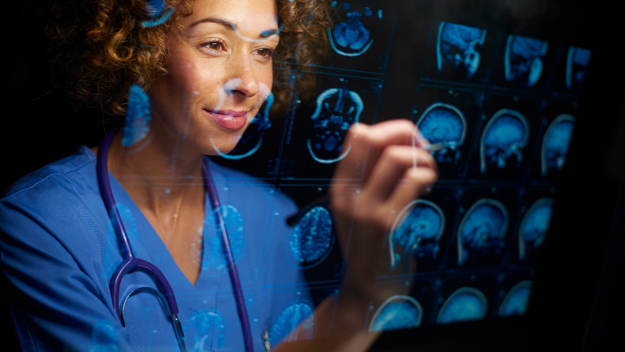 a female doctor or surgeon is analysing the digitally generated scans of a human brain