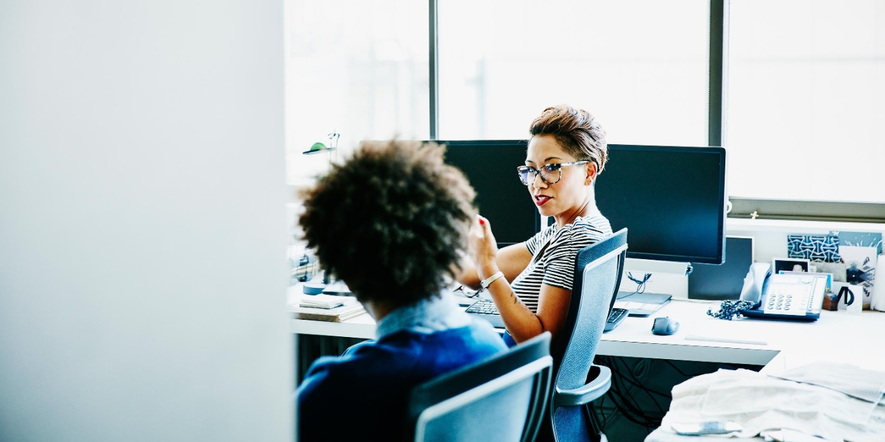 Office worker talking to a colleague at a desk