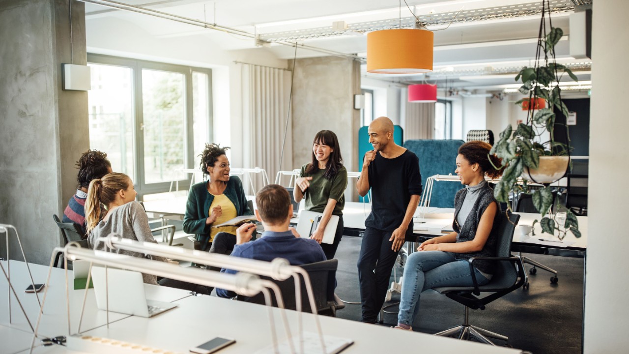 Happy multi-ethnic people discussing in meeting at creative office