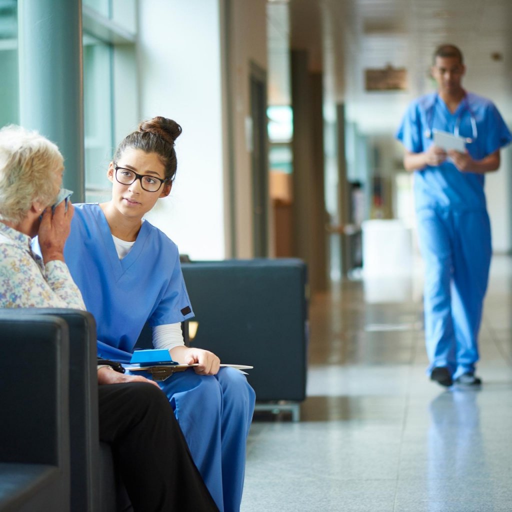 A female nurse consoles an upset patient