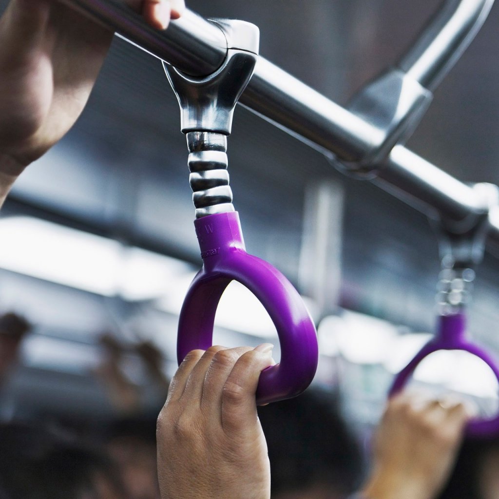 a hand holding hand rail on public transit