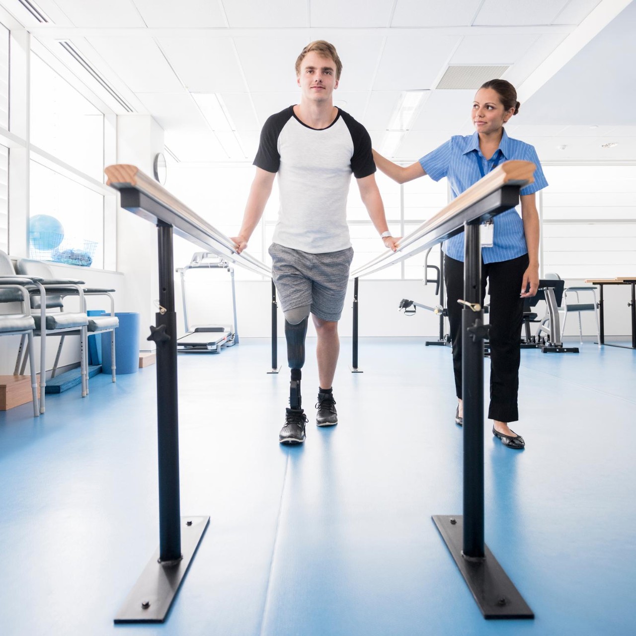 female-physiotherapy-helping-young-male-amputee-to-walk