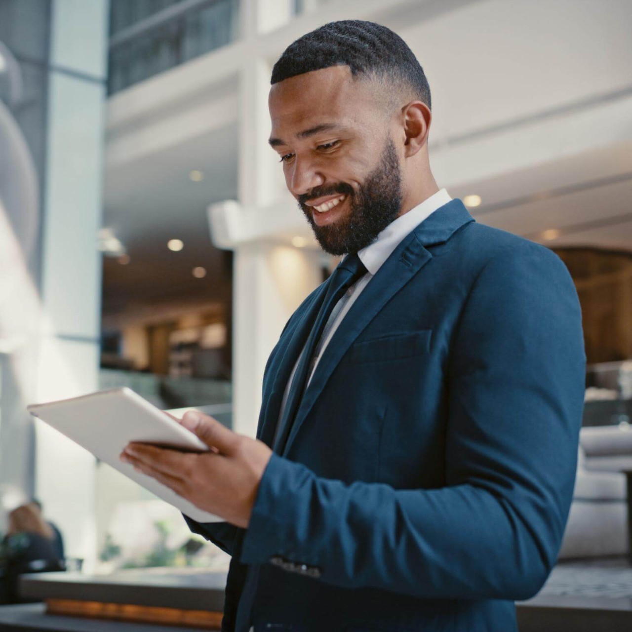 Businessman, holding digital tablet at hotel conference lobby