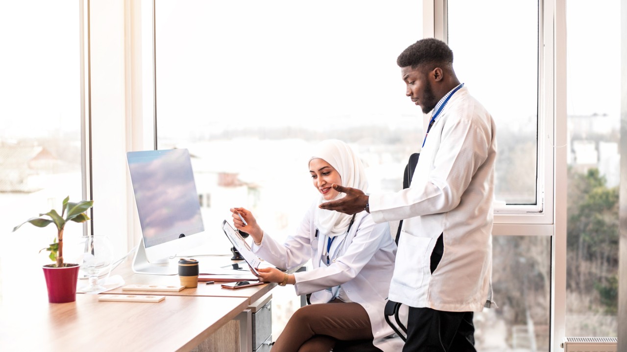 Two medical doctors looking reports at the light medical office.