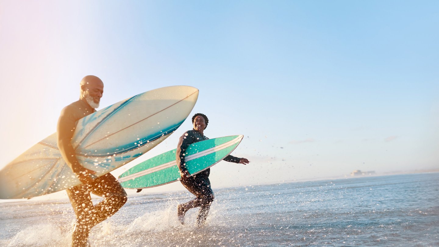  Shot of a mature couple surfing at the beach